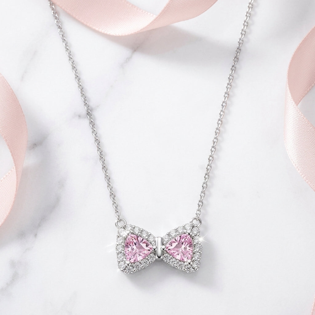 Necklace with a pink bow-shaped pendant on a light background