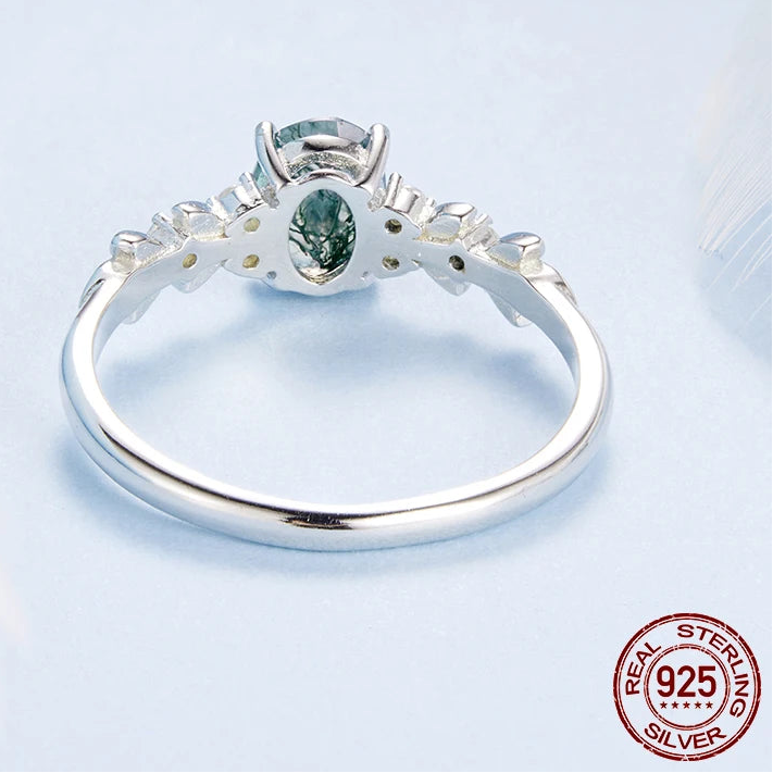 Silver ring with a green gemstone on a light gray background, featuring the brand 'PALASH'.


