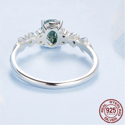 Silver ring with a green gemstone on a light gray background, featuring the brand 'PALASH'.

