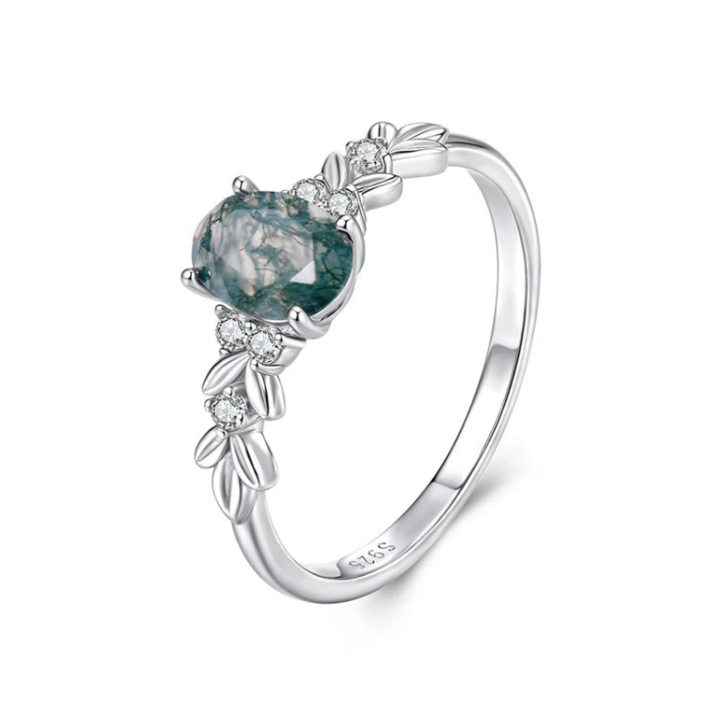 Silver ring with a green gemstone and leaf designs 