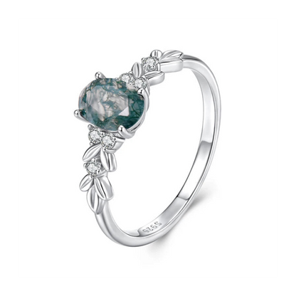 Silver ring with a green gemstone and leaf designs 